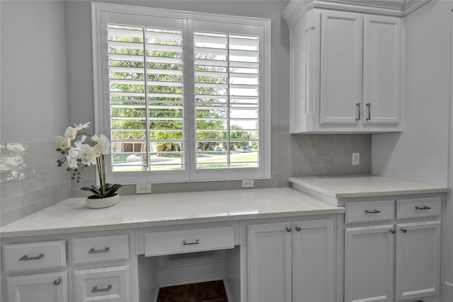 kitchen with light countertops, tasteful backsplash, and white cabinets