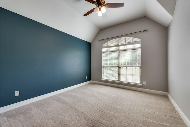 empty room with light carpet, baseboards, and lofted ceiling