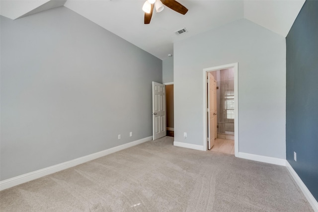 unfurnished bedroom with lofted ceiling, baseboards, light carpet, and visible vents