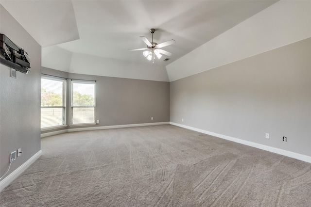 spare room featuring lofted ceiling, light carpet, ceiling fan, and baseboards