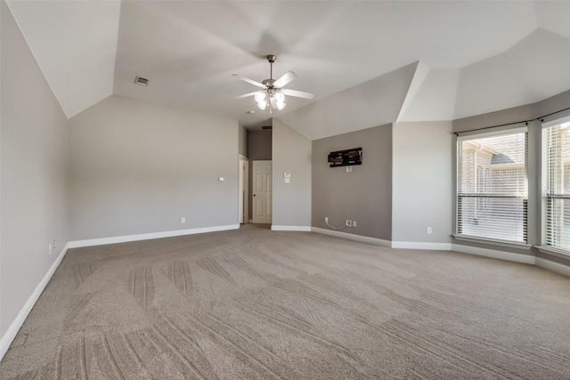 carpeted empty room featuring visible vents, vaulted ceiling, baseboards, and ceiling fan