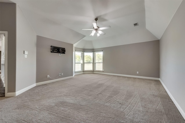 empty room with light carpet, baseboards, visible vents, a ceiling fan, and vaulted ceiling