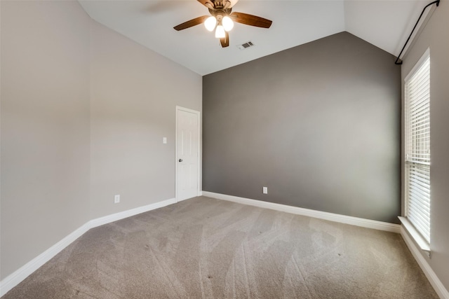 unfurnished room featuring carpet floors, lofted ceiling, visible vents, a ceiling fan, and baseboards