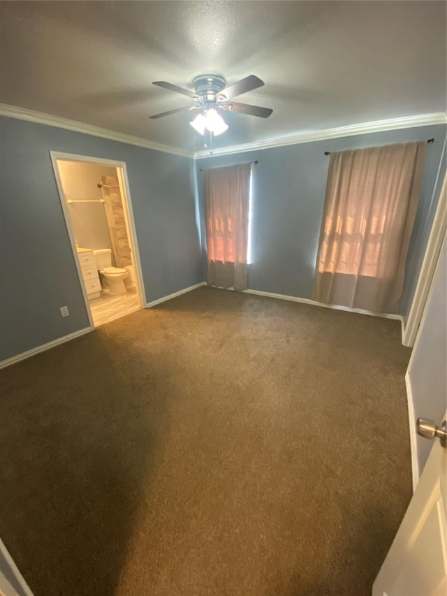 unfurnished bedroom with carpet floors, baseboards, crown molding, and ensuite bathroom