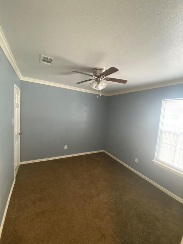 unfurnished room with dark carpet, visible vents, crown molding, and baseboards