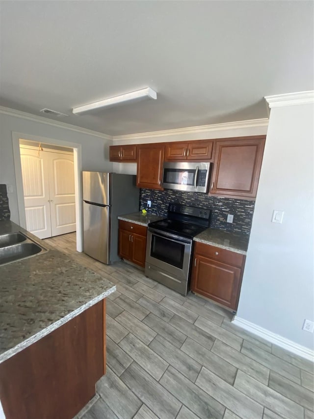 kitchen with tasteful backsplash, visible vents, appliances with stainless steel finishes, ornamental molding, and a sink