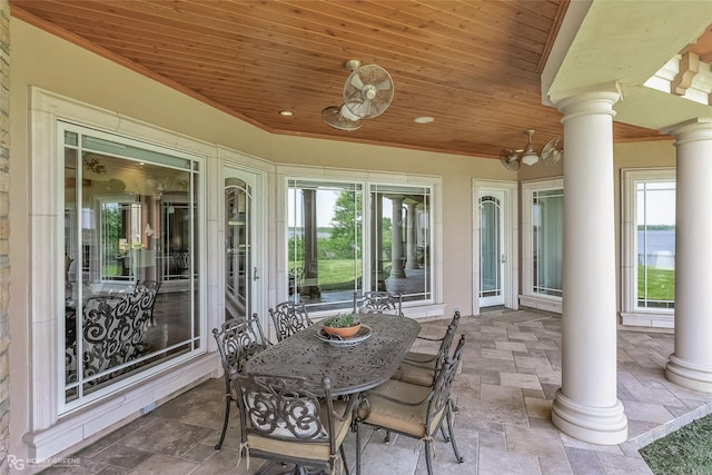 view of patio with a water view and a ceiling fan