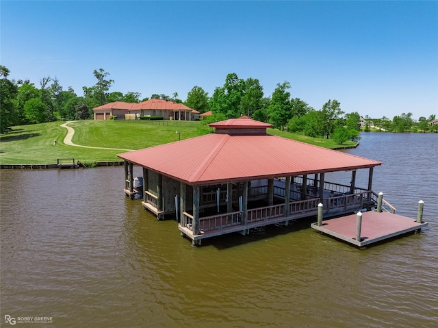 dock area with a water view, a yard, and boat lift