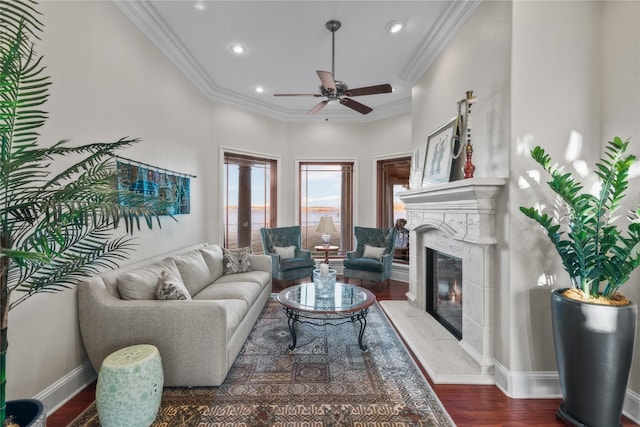 living area featuring recessed lighting, a premium fireplace, baseboards, dark wood finished floors, and crown molding