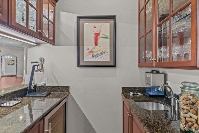 bar featuring indoor wet bar, a sink, and a textured wall