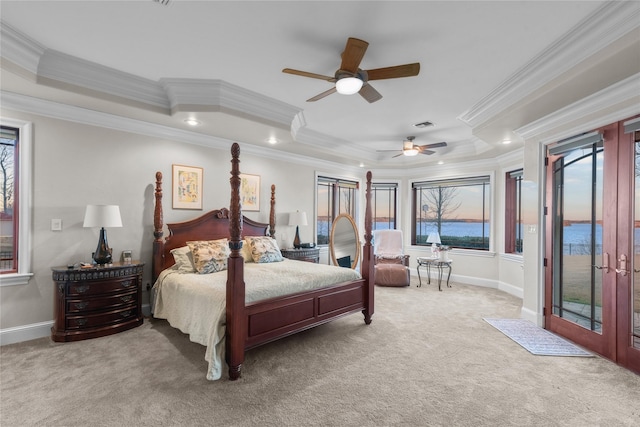 bedroom featuring light carpet, access to outside, a tray ceiling, and a water view