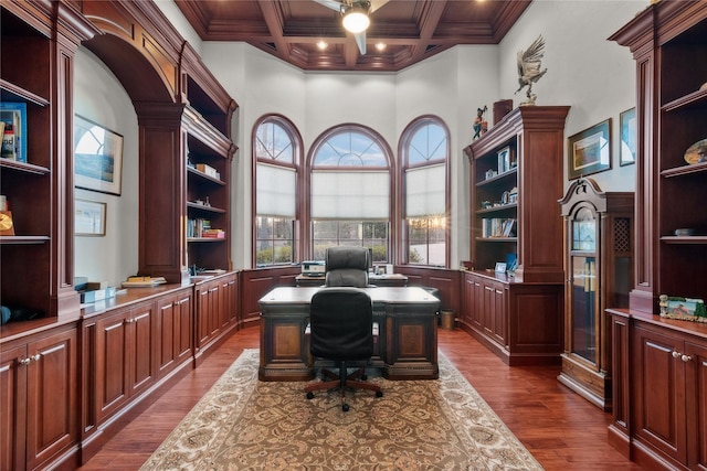 home office with dark wood-type flooring, coffered ceiling, beamed ceiling, and crown molding