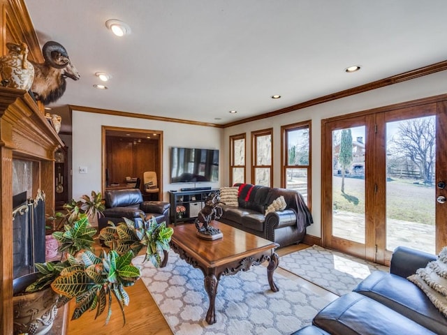 living room with recessed lighting, ornamental molding, a fireplace, and wood finished floors