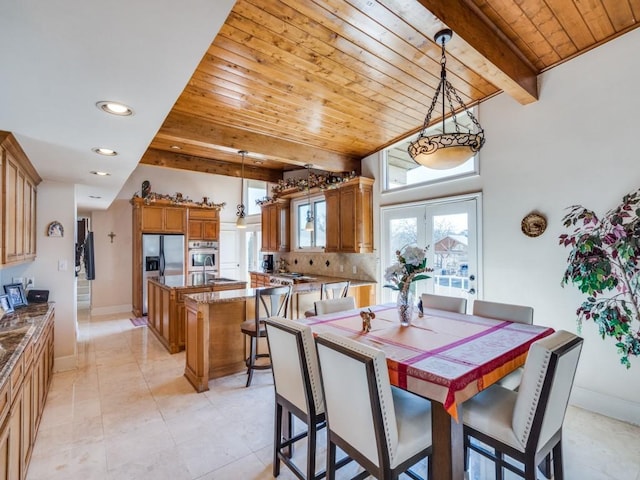 dining room featuring beamed ceiling, wooden ceiling, and baseboards