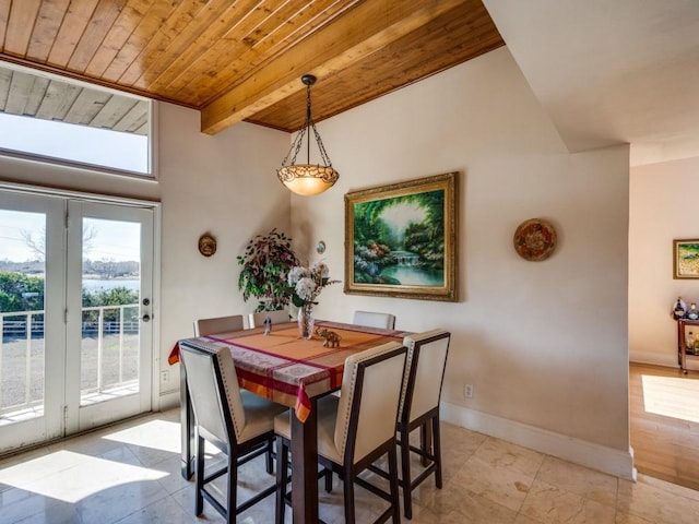 dining room featuring beamed ceiling, baseboards, and wooden ceiling