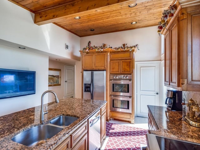 kitchen featuring brown cabinets, wood ceiling, stainless steel appliances, and a sink