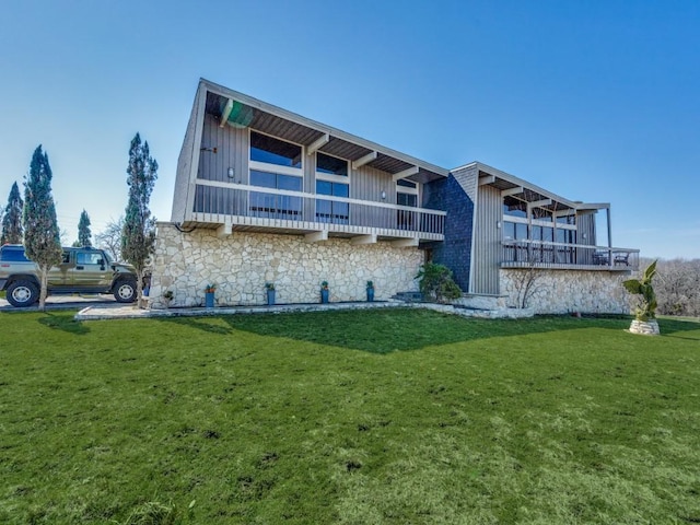 exterior space with stone siding, a lawn, and board and batten siding