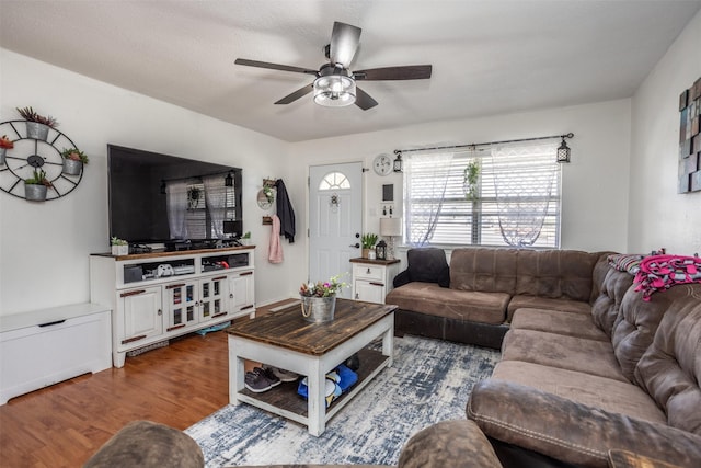 living area with dark wood-style floors and a ceiling fan