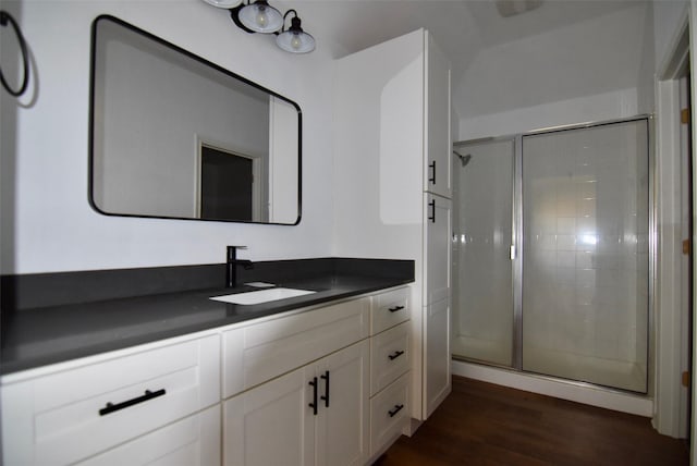 full bathroom featuring a stall shower, vanity, and wood finished floors