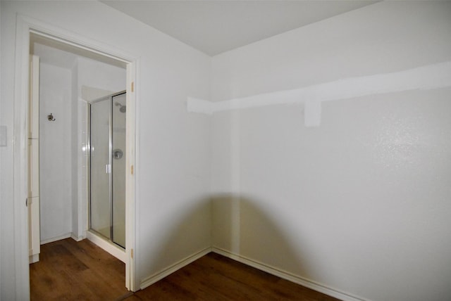 bathroom featuring a shower stall, baseboards, and wood finished floors