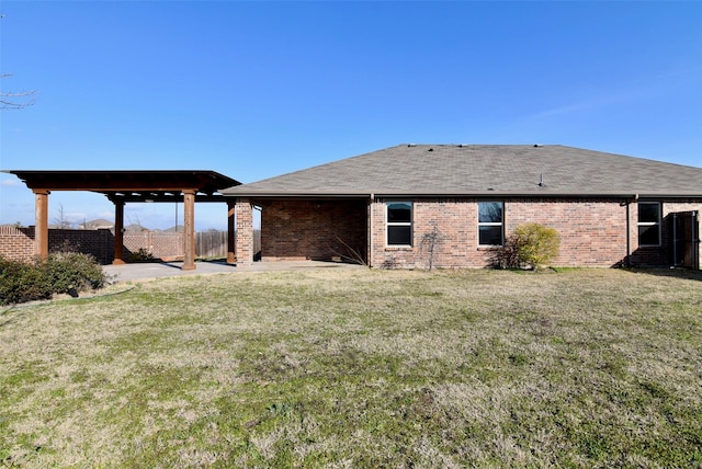 rear view of property with a patio area, brick siding, a lawn, and fence