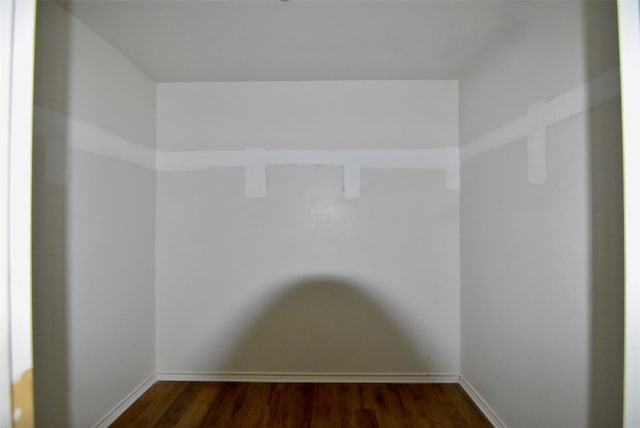 spare room featuring dark wood-style floors and baseboards