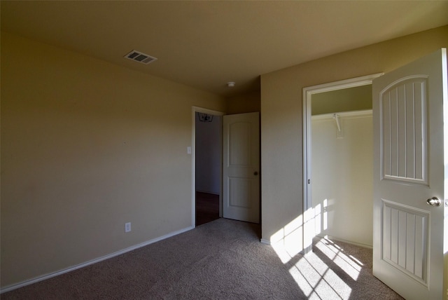 unfurnished bedroom featuring visible vents, light carpet, and baseboards