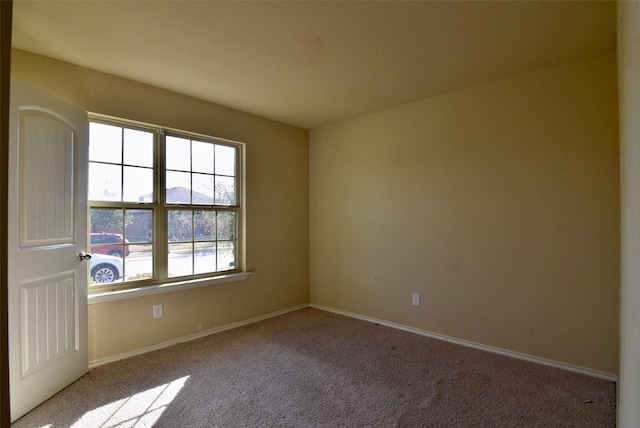 unfurnished room with light carpet and baseboards