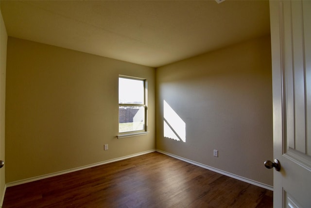 empty room featuring baseboards and wood finished floors