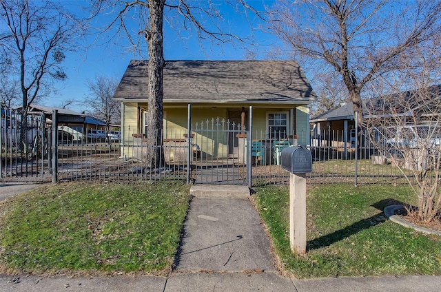 view of front of property with a fenced front yard, a gate, roof with shingles, and a front lawn