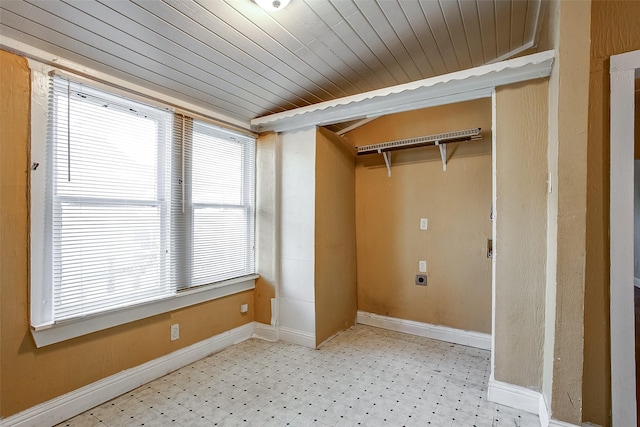 clothes washing area featuring wooden ceiling, light floors, baseboards, and electric dryer hookup