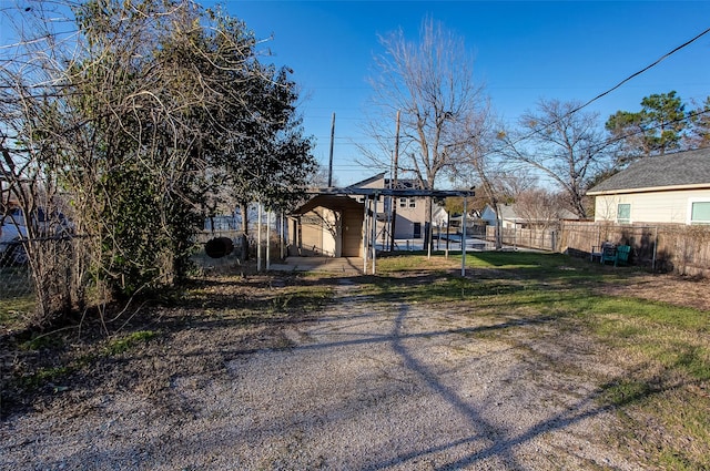 view of yard featuring a carport and fence