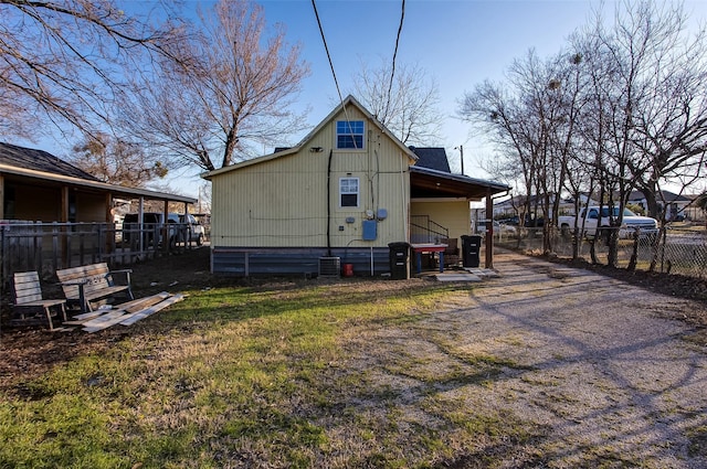 back of house featuring central AC and fence