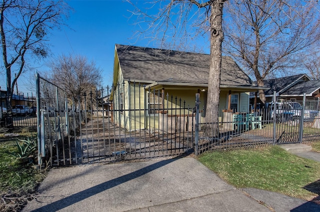 bungalow with a fenced front yard, a gate, and roof with shingles