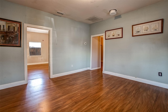 unfurnished room with visible vents, baseboards, and wood finished floors