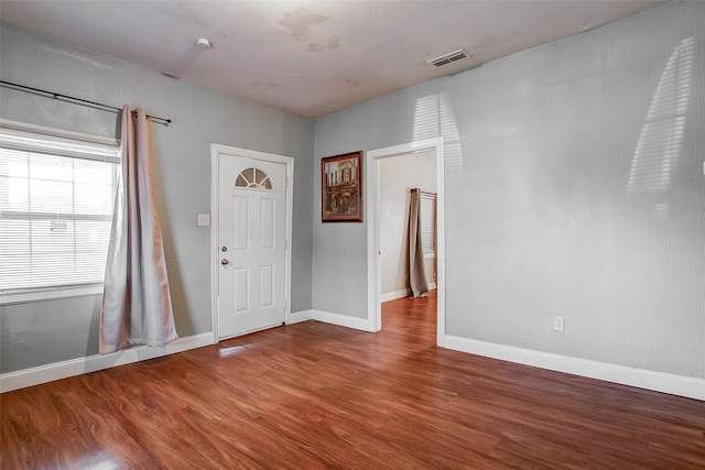 entrance foyer with wood finished floors, visible vents, and baseboards