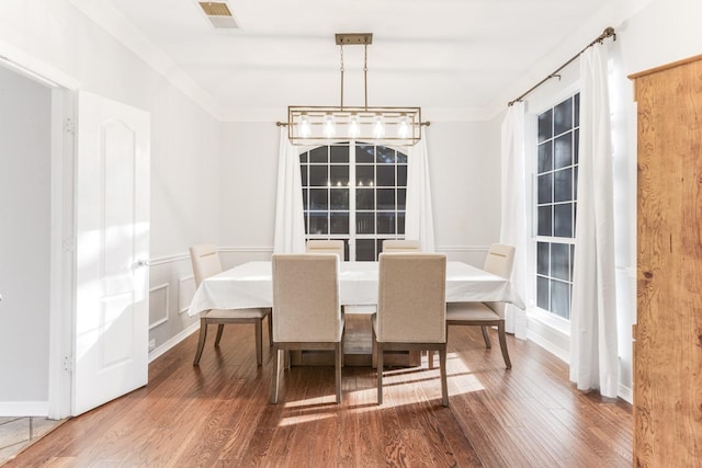 dining area featuring visible vents, wood finished floors, and crown molding