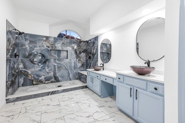 bathroom with double vanity, marble finish floor, a walk in shower, and a sink