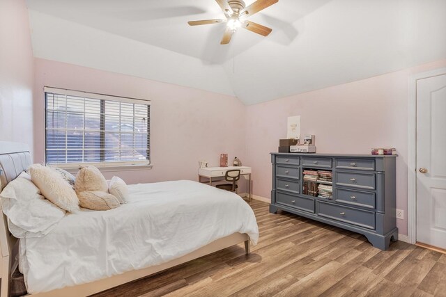 bedroom featuring lofted ceiling, light wood-style floors, baseboards, and ceiling fan