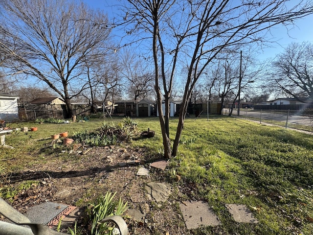 view of yard featuring an outbuilding, a fenced backyard, and a storage unit