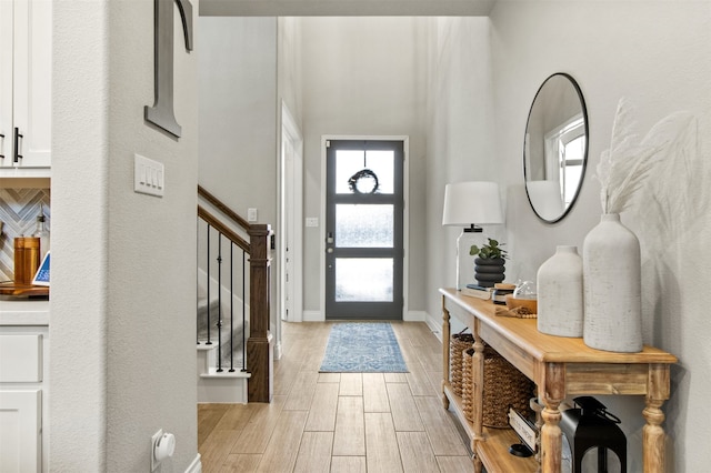 foyer with stairs, baseboards, and wood tiled floor