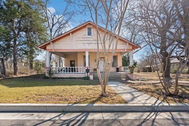 view of front of house featuring covered porch and a front lawn