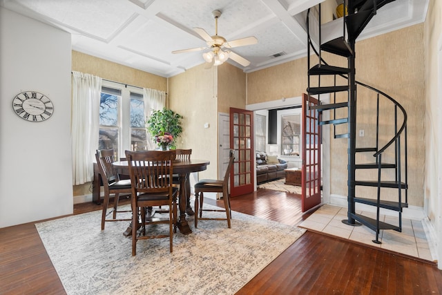 dining space featuring coffered ceiling, a ceiling fan, hardwood / wood-style floors, stairs, and french doors