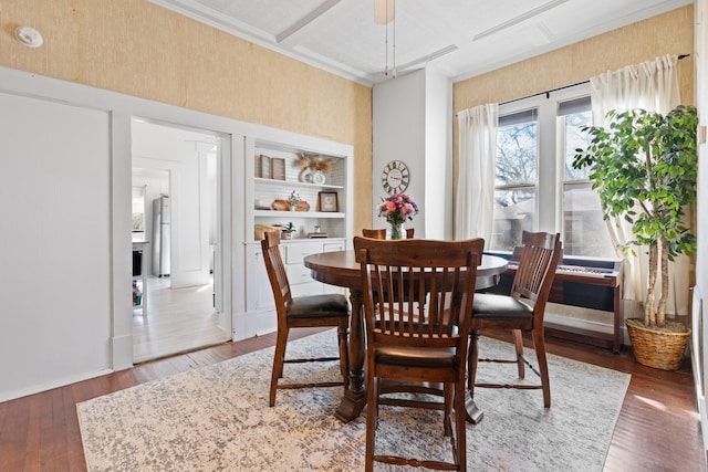 dining room with coffered ceiling and hardwood / wood-style floors