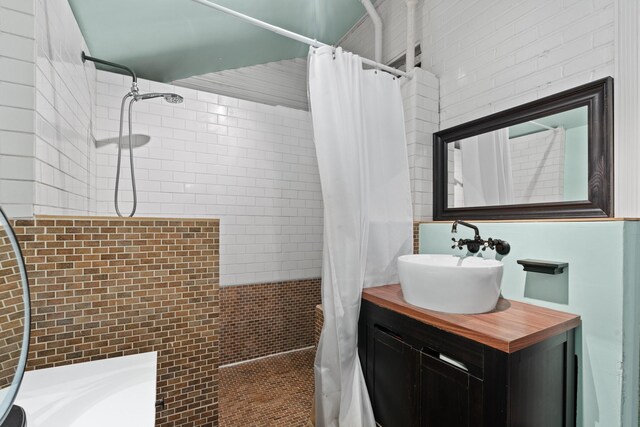 bathroom featuring tiled shower and vanity