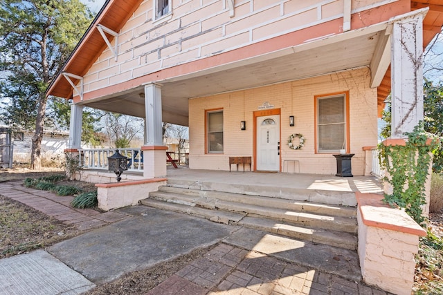 view of front facade featuring a porch and brick siding