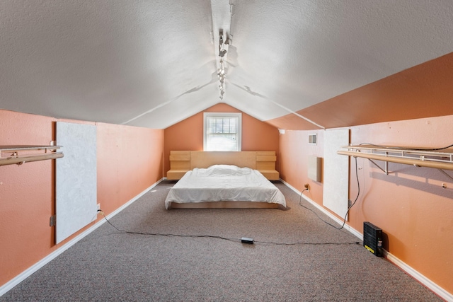 unfurnished bedroom with carpet, visible vents, vaulted ceiling, a textured ceiling, and baseboards