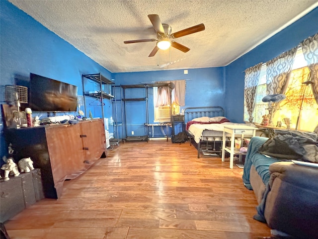 bedroom featuring a textured ceiling, wood finished floors, and a ceiling fan