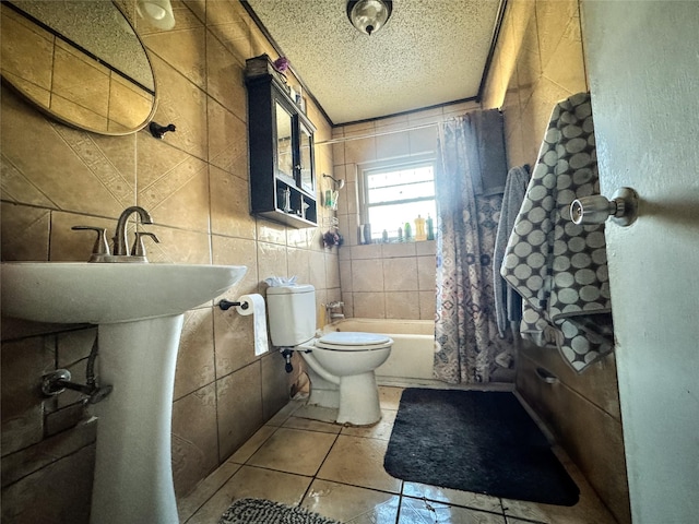 full bath featuring toilet, tile patterned floors, shower / bathtub combination with curtain, a textured ceiling, and tile walls