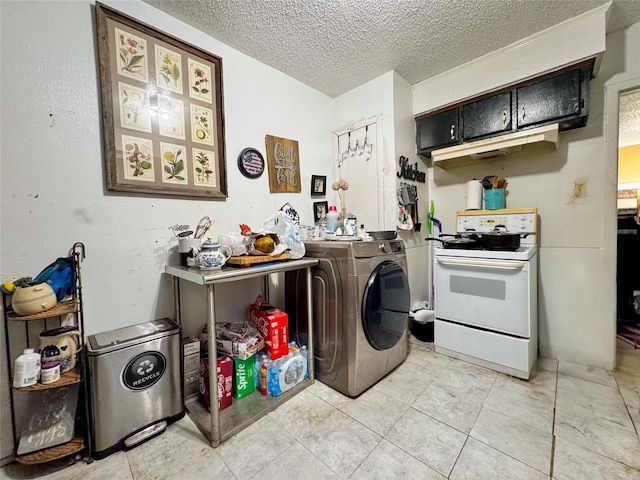 clothes washing area featuring a textured ceiling, laundry area, washer / clothes dryer, and light tile patterned flooring